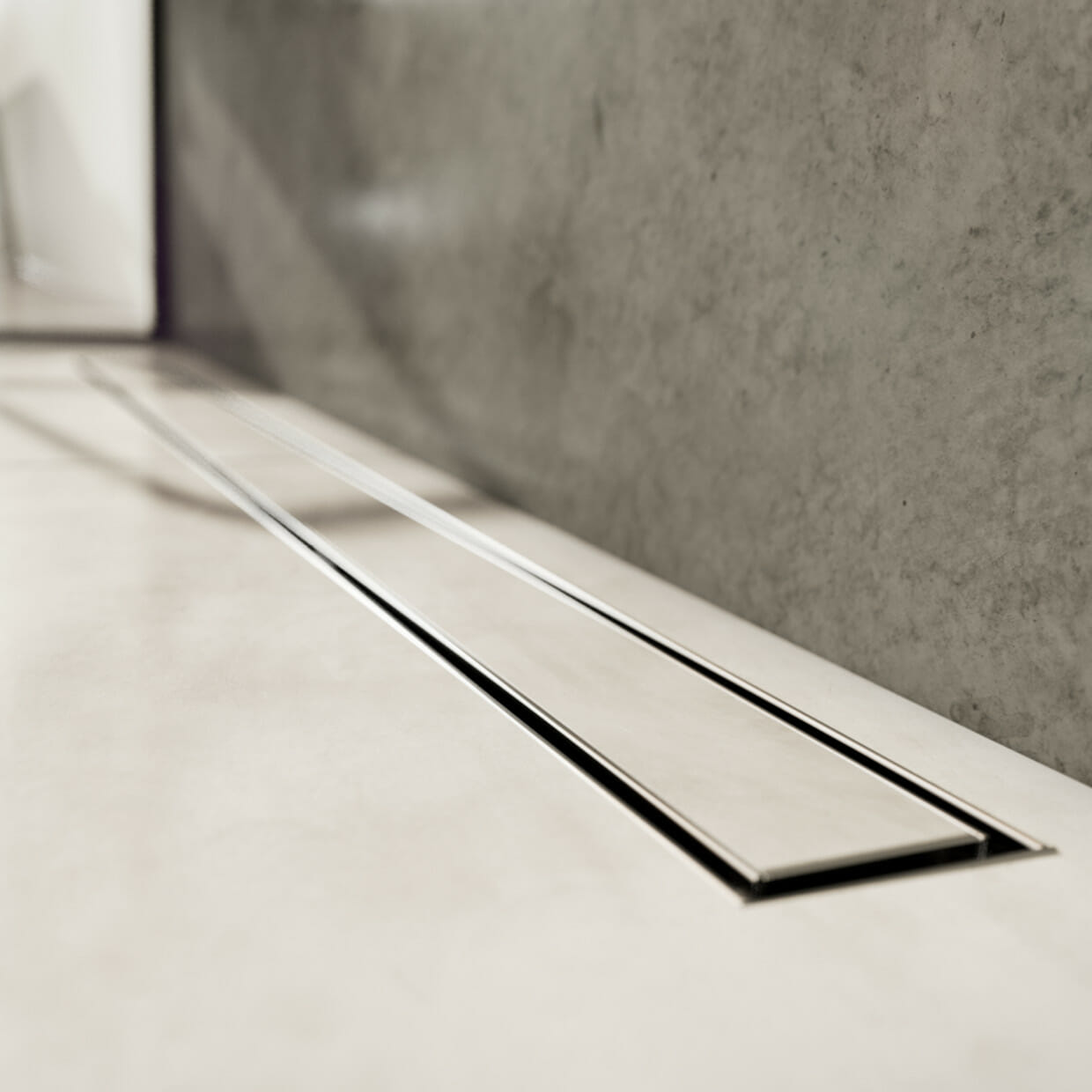 Nahaufnahme der ACO ShowerDrain C Duschrinne mit befliestem Tile Designrost in gefliestem Duschbereich vor Betonwand
